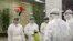 State Commission of Quality Management staff in protective gear and wielding disinfectant prepare to check the health of travelers arriving from abroad at the Pyongyang Airport in Pyongyang, North Korea, Feb. 1, 2020.