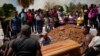 Los residentes colocan el ataúd que contiene los restos del minero Richard Bastardo, en una tumba en el cementerio de La Paragua, estado Bolívar, Venezuela, el jueves 22 de febrero de 2024. (Foto AP/Ariana Cubillos)