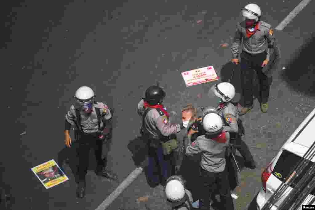 A demonstrator is detained by riot police officers during a protest against the military coup in Yangon, Myanmar, Feb. 28, 2021.