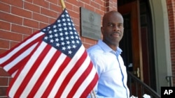 FILE - In this June 12, 2020, photo, Gregory Minott stands in front of Town Hall in Andover, Mass. Minott came to the U.S. from Jamaica more than two decades ago on a student visa and was able to carve out a career in architecture. He is now a U.S. citizen.