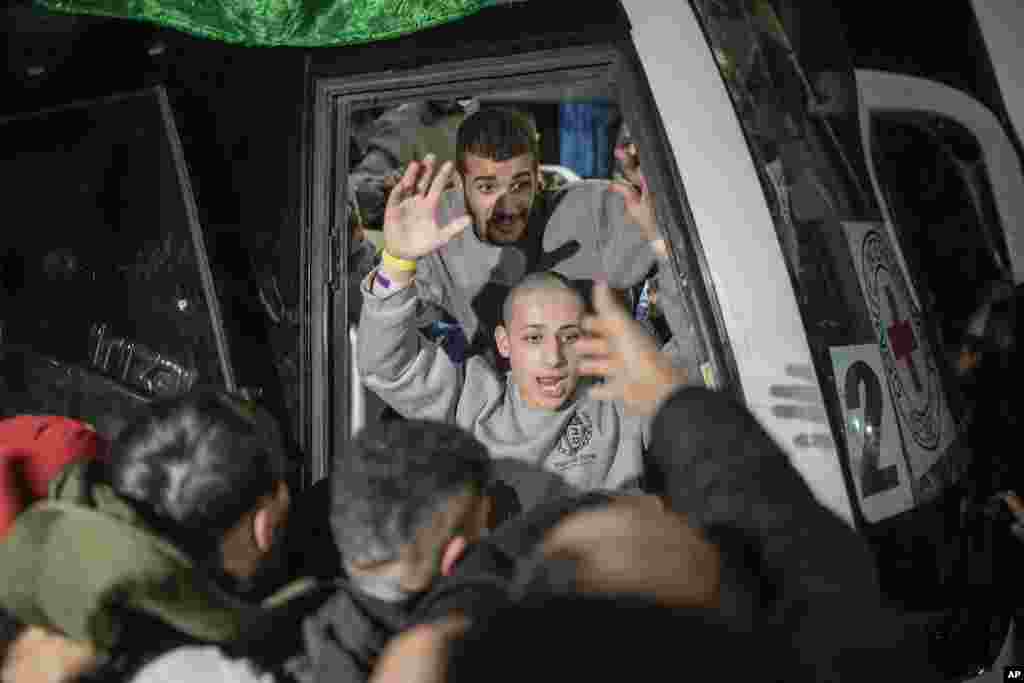 A Palestinian prisoner is greeted as he disembarks from a bus after being released from an Israeli prison, in the West Bank city of Beitunia.