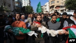 Palestinian mourners carry the bodies of members of the al-Dallu family during a funeral procession in Gaza City on November 19, 2012.