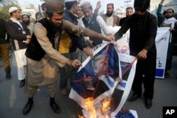 FILE - Pakistani protesters burn posters of U.S. President Donald Trump in Lahore, Pakistan, Jan. 5, 2018. Pakistan has expressed disappointment at the U.S. decision to suspend military aid to Islamabad.