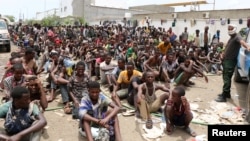 Ethiopian migrants, stranded in war-torn Yemen, sit on the ground of a detention site pending repatriation to their home country, in Aden, Yemen, April 24, 2019.
