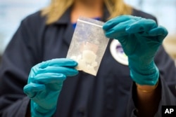 FILE - A bag of 4-fluoro isobutyryl fentanyl which was seized in a drug raid is displayed at the Drug Enforcement Administration (DEA) Special Testing and Research Laboratory in Sterling, Virginia, Aug. 9, 2016.