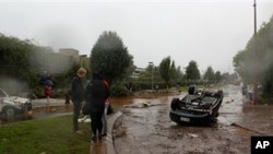 People survey the damage after a flash flood tossed vehicles down a street in Toowomba, Australia, 10 Jan 2011