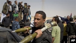 A rebel carries Rocket Propelled Grenades (RPG) after taking Ajdabiya, south of Benghazi, eastern Libya, March 26, 2011