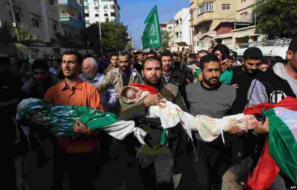 Palestinian mourners carry the bodies of members of the al-Dallu family during a funeral procession in Gaza City on November 19, 2012.