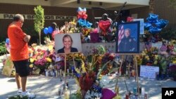 A visitor pays his respect at a memorial for Palm Springs Police Officers Lesley Zerebny, and Jose "Gil" Gilbert Vega.