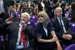 FILE - Stanley, Rachel and Jo Johnson, Boris Johnson's father, sister and brother, wait for the announcement that he has been elected leader of the Conservative party, at the Queen Elizabeth II Centre in London, July 23, 2019.