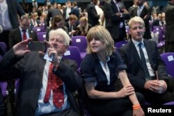 FILE - Stanley, Rachel and Jo Johnson, Boris Johnson's father, sister and brother, wait for the announcement that he has been elected leader of the Conservative party, at the Queen Elizabeth II Centre in London, July 23, 2019.