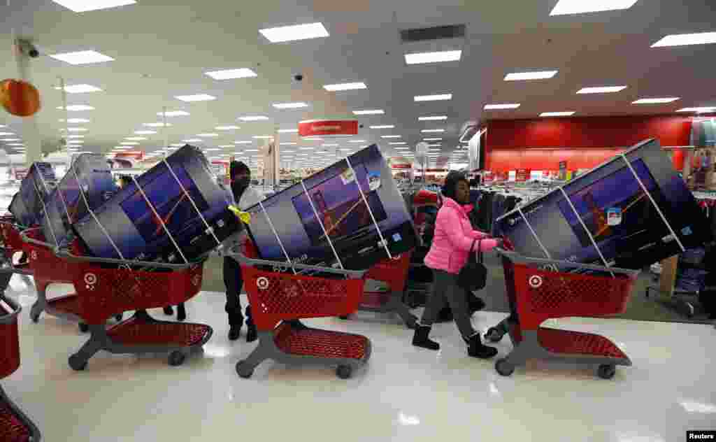 Thanksgiving Day holiday shoppers line up with television sets on discount at the Target retail store in Chicago, Illinois, Nov. 28, 2013.