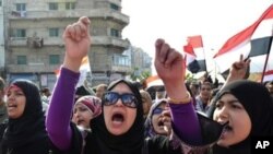 Egyptian protestors wave national flags and shout anti-government slogans during mass rally in the northern Mediterranean port of Alexandria on November 25, 2011.