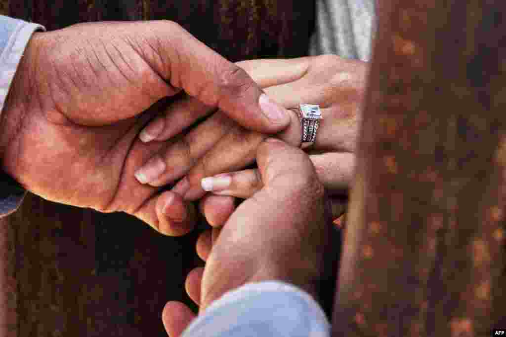 Rogelio puts a wedding ring on Miriam&#39;s finger as they get married through the border wall between Mexico and the United States, during the &quot;Keep our dream alive&quot; event, in Ciudad Juarez, Chihuahua state, Mexico, Dec. 10, 2017.