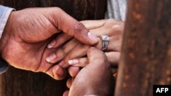 Seorang pria memasangkan cincin perkawinan kepada pengantin perempuan, sebagai ilustrasi. (Foto: AFP)