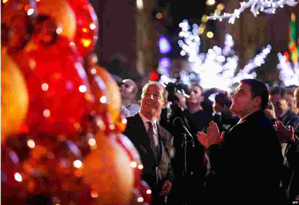 Премьер-министр Мальты Лоуренс Гонци (в центре) и мэр Валетты Алексей Дингли зажигают огни на столичной рождественской елке, украшенной двумя тысячами стеклянных шаров. Фото Reuters