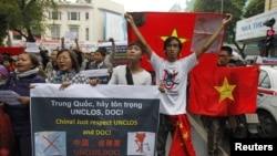 Anti-China protesters hold Vietnamese national flags and anti-China banners while marching on a street in Hanoi, December 9, 2012. 