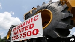 FILE - A help wanted sign is posted at a tractor dealership in Ashland, Va., June 9, 2015. 