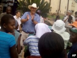 Farmer Darryn Smart, center, son of Robert Smart, and his family are welcomed back to their farm, Lesbury, by workers and community members, Dec. 21, 2017, in Tandi, Zimbabwe.