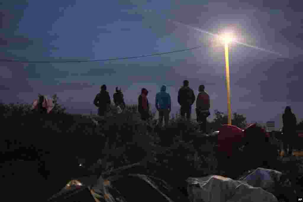 Migrants stand near the camp known as the New Jungle in Calais, northern France, Sept. 2, 2015. Britain and France are fortifying control of the Channel Tunnel and boosting intelligence efforts against traffickers as they try to dissuade thousands of migrants from trying to make the illegal and sometimes deadly undersea journey to British shores.