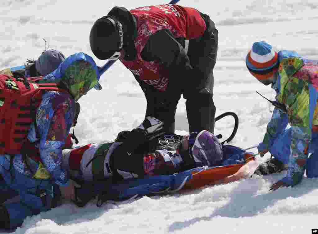 Petugas meletakkan Michela Moioli di tandu setelah tabrakan pada nomor final snowboarding putri di Taman Rosa Khutor, di Krasnaya Polyana, Rusia, 16 Februari 2014.