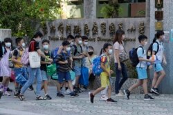 Siswa SD mengenakan masker, berjalan menuju gerbang sekolah di Taipei, Taiwan, Rabu, 1 September 2021.