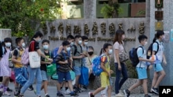 Siswa SD yang memakai masker berjalan memasuki gerbang sekolah di Taipei, Taiwan, Rabu, 1 September 2021. (Foto: AP)