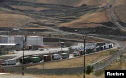 FILE - Trucks are seen at Haj Omran border, on the border between Iran and Kurdistan, Iraq, Oct. 14, 2017. Improving soil health could capture extra carbon equivalent to the emissions generated by the transport sector, experts said.