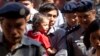 Reuters journalist Kyaw Soe Oo carries his daughter as he is escorted by Myanmar police to trial after a break, Feb. 1, 2018, outside of Yangon, Myanmar. A lawyer for the two Reuters journalists Wa Lone and Kyaw Soe Oo, charged with illegally handling government secrets, says a court had denied their request to be released on bail. 