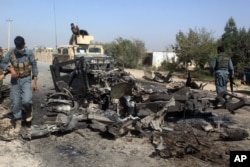 FILE - Afghan security forces inspect the site of a U.S. airstrike in Kunduz city, north of Kabul, Afghanistan, Oct. 2, 2015.