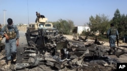 아프간 보안군들이 쿤두즈 시 미 공습 피해 현장을 조사하고 있다