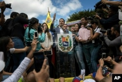 Venezuela's self-declared interim leader Juan Guaido speaks to supporters during a gathering to propose amnesty laws for police and military, at a public plaza in Las Mercedes neighborhood of Caracas, Venezuela, Saturday, Jan. 26, 2019. (AP Photo)