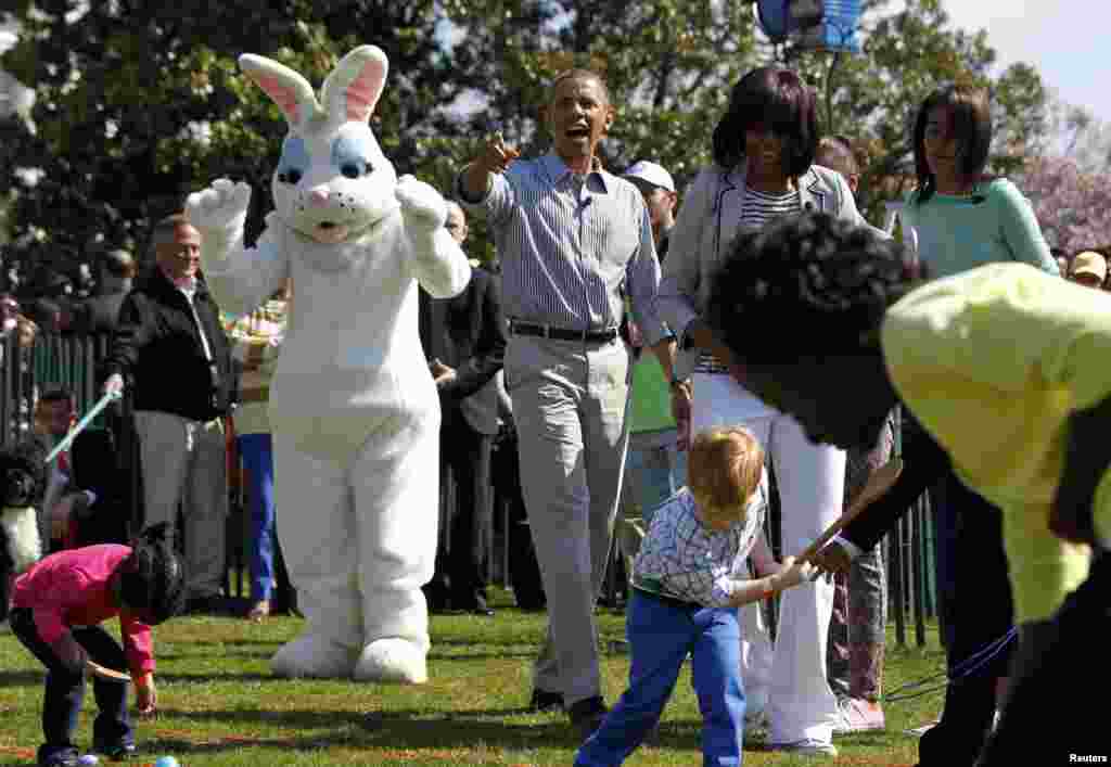 Presiden AS Barack Obama dan ibu negara Michelle Obama dan puteri mereka, Malia Obama, menyaksikan pertandingan selama lomba tahunan Telur Paskah ke-135 untuk anak-anak di Gedung Putih. 