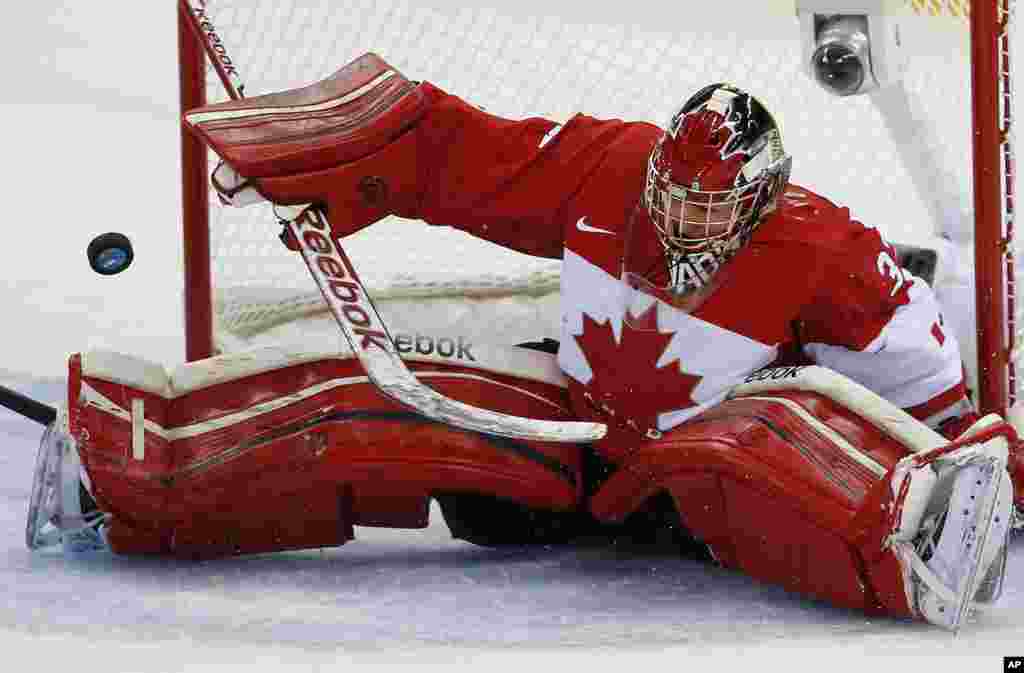 Penjaga gawang tim hoki es putri Kanada menepis bola saat bertanding melawan tim AS di Arena Shayba, Sochi, Rusia.