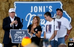 Republican presidential candidate Donald Trump shares the stage with the family of Sarah Root at a campaign event at the Iowa State Fairgrounds in Des Moines, Aug. 27, 2016. Root was killed this year after her car was hit by another. The driver, who was drunk, was a reportedly Honduran immigrant living in the country illegally.