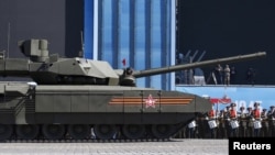 A Russian serviceman holds a red flag onboard a T-14 Armata tank after it stopped during a rehearsal for the Victory Day parade in Red Square in central Moscow, Russia, May 7, 2015.