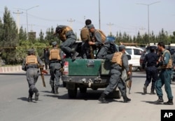 FILE - Afghan security personnel arrive at the site of a deadly attack on the Interior Ministry, in Kabul, Afghanistan, May 30, 2018.