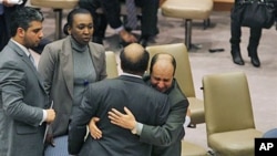 Libya's deputy UN ambassador Ibrahim Dabbashi, right, hugs Libya's UN ambassador Mohamed Shalgham after a meeting of the Security Council at United Nations headquarters in New York, February 25, 2011