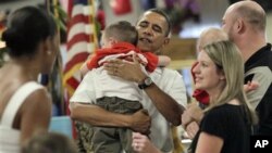 President Barack Obama and first lady Michelle Obama, far left, greet members of the military and their families during Christmas dinner at Anderson Hall on Marine Corps Base Hawaii in Kaneohe, Hawaii, 25 Dec 2010