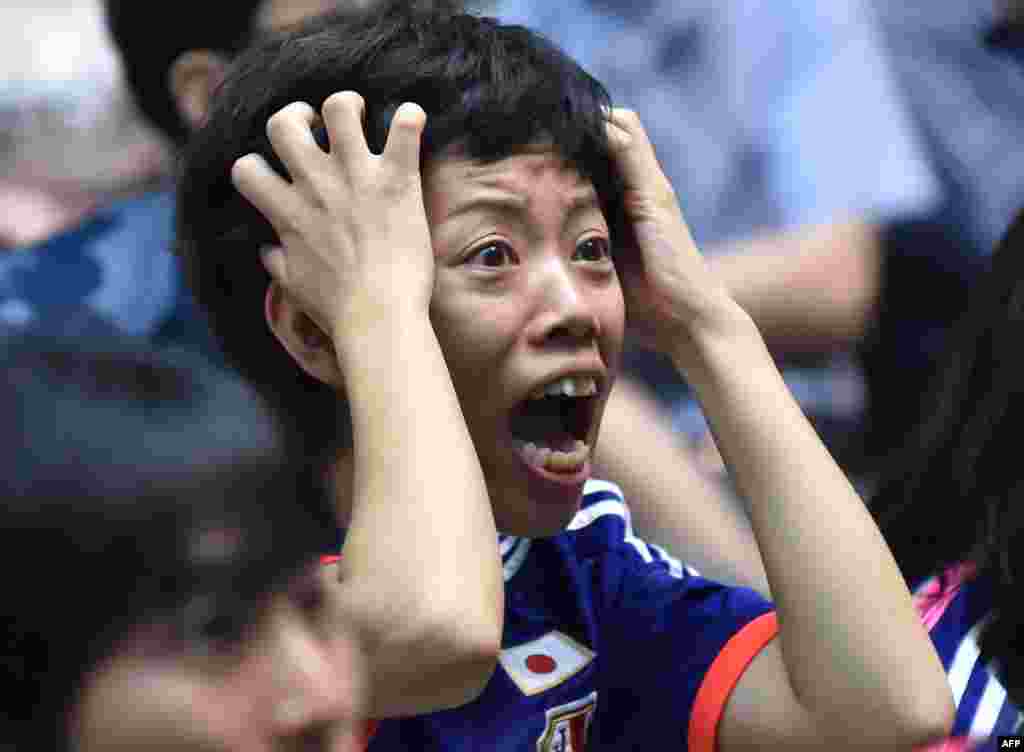 A Japanese football supporter reacts as she attends a public screening in Tokyo of the 2015 FIFA Women&#39;s World Cup final between Japan and USA being played in Vancouver, British Columbia.