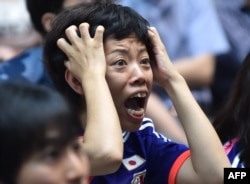 TOPSHOTSA Japanese football supporter reacts as she attends a public screening in Tokyo on July 6, 2015, of the 2015 FIFA Women's World Cup final between Japan and USA being played in Vancouver, British Columbia. AFP PHOTO / KAZUHIRO NOGI