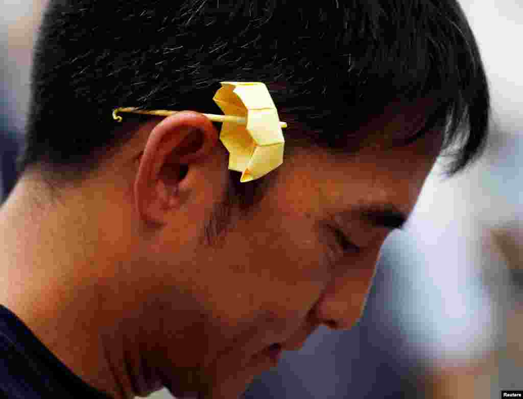 A man with a yellow origami umbrella, symbol of the Occupy Central civil disobedience movement, takes part in the second anniversary of the movement outside government headquarters in Hong Kong.