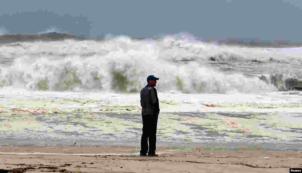 A man stands on the beach to watch the storm surf in Southampton, New York, October 29, 2012. 
