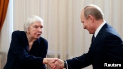 FILE - Russian President Vladimir Putin shakes hands with Lyudmila Alekseyeva, head of the Moscow Helsinki Group, before meeting with Russian human rights activists in Novo-Ogaryovo, a presidential residence outside Moscow, Jan. 23, 2014.