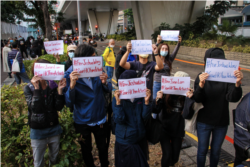 Sejumlah aktivis pro-demokrasi menunjukkan poster di luar Pengadilan West Kowloon setelah Joshua Wong, Agnes Chow, dan Ivan Lam divonis hukuman penjara, Rabu, 2 Desember 2020. (Foto: Tommy Walker/VOA)