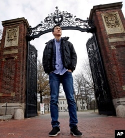 Harvard University graduate Jin K. Park, who holds a degree in molecular and cellular biology, poses at a gate at Harvard Yard in Cambridge, Mass., Thursday, Dec. 13, 2018. (AP Photo/Charles Krupa)