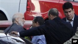 Surrounded by security forces, US government contractor Alan Gross, left, arrives to a courthouse to attend a trial in Havana, Cuba, March 5, 2011