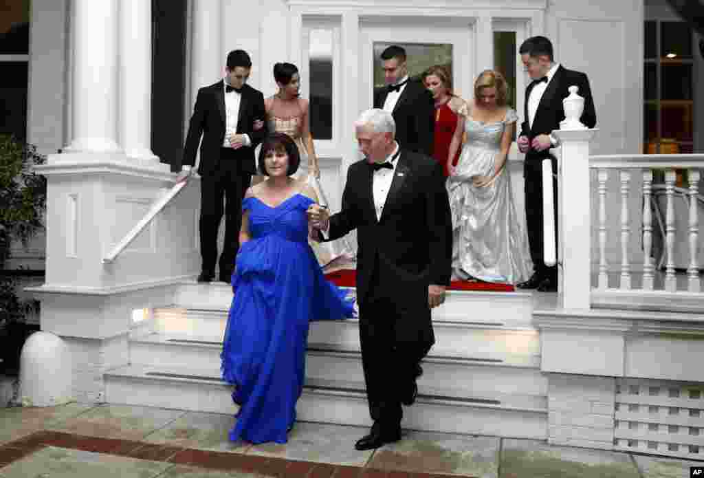 Vice President Mike Pence assists his wife, Karen, as they depart the Naval Observatory for several inaugural balls, Jan. 20, 2017 in Washington.