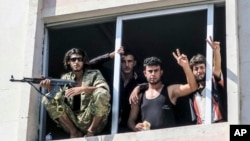 FILE - Free Syrian Army fighters give the victory sign, in Jarablus, Syria. Veteran Syrian rebels who have fought Assad for years are struggling to find a place in a bewildering battlefield where several wars are all being waged at once by international powers, Aug. 31, 2016. 
