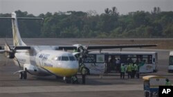 International and national staffs of non-governmental organizations transfer into a bus upon arriving in domestic airport in Yangon from Sittwe, Thursday, Mar 27, 2014.